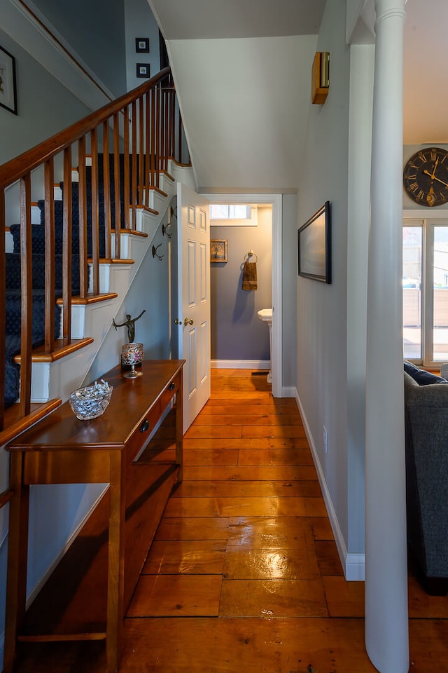 hallway with wood-type flooring and ornate columns