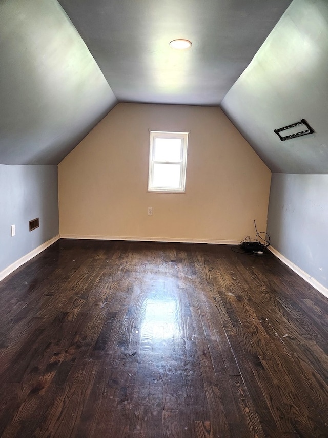 bonus room with dark hardwood / wood-style flooring and vaulted ceiling