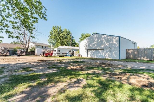 view of yard with a garage and an outbuilding