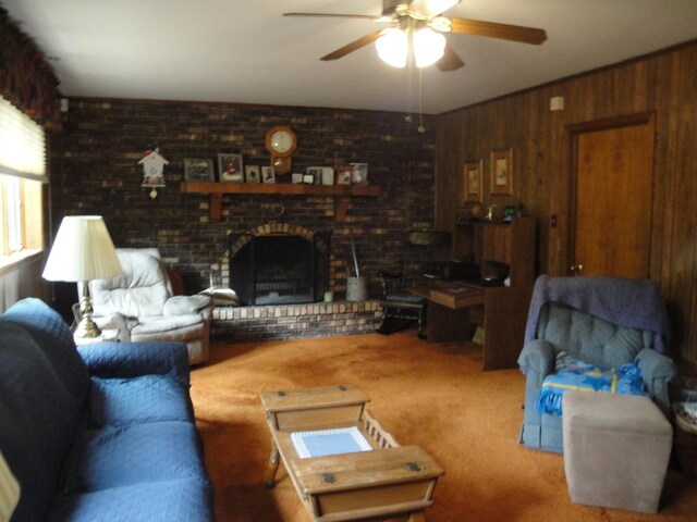 living room featuring brick wall, wooden walls, a brick fireplace, carpet flooring, and ceiling fan