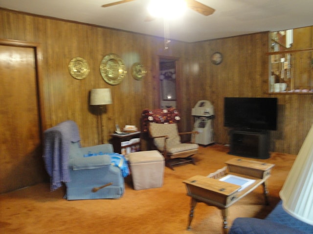 living room with carpet floors, ceiling fan, and wood walls