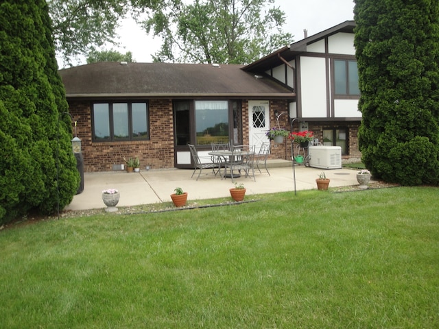 rear view of house featuring a patio, central air condition unit, and a lawn