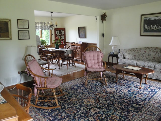 living room featuring wood-type flooring and an inviting chandelier