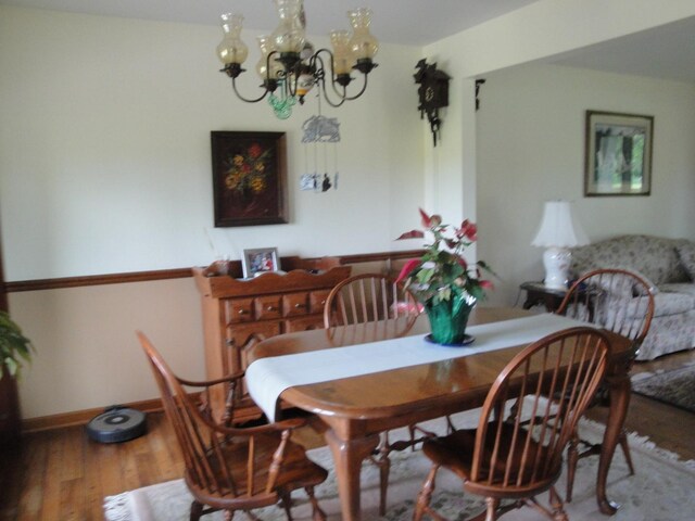 dining area with a notable chandelier and hardwood / wood-style floors