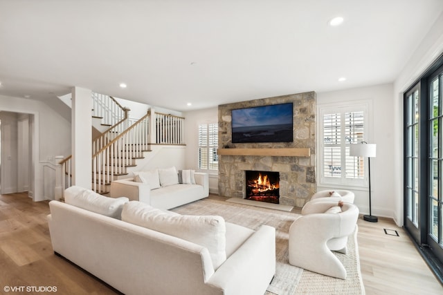 living room featuring a healthy amount of sunlight, a fireplace, and light hardwood / wood-style flooring