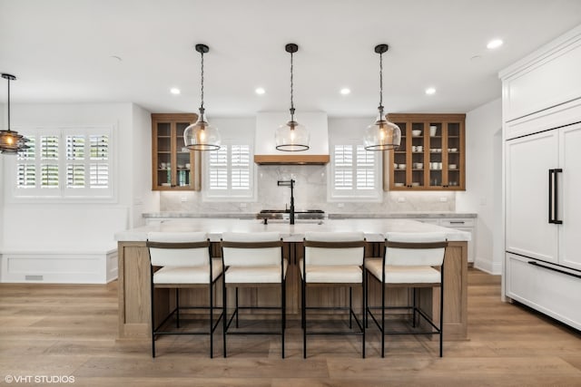 kitchen featuring a center island, light wood-type flooring, and paneled built in refrigerator