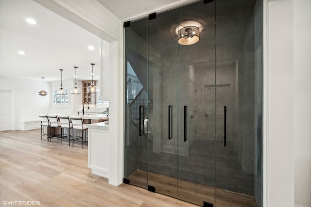 bathroom with walk in shower, vanity, and wood-type flooring