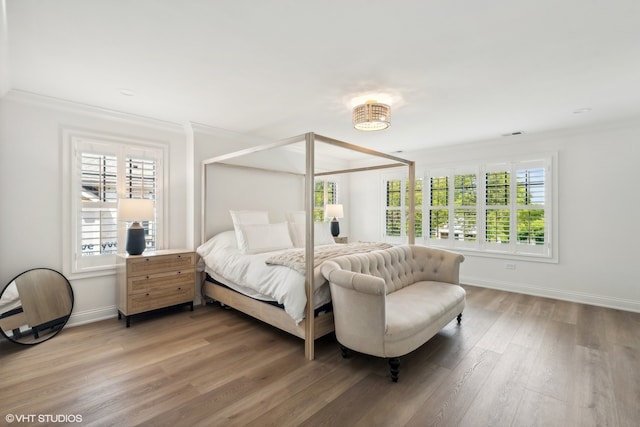 bedroom featuring wood-type flooring and ornamental molding