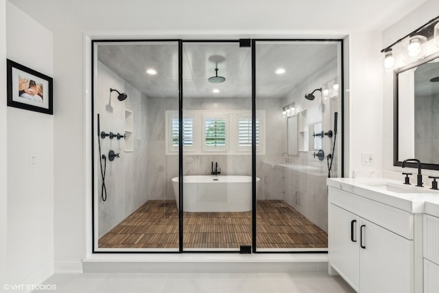 bathroom with tile floors, a shower with shower door, and vanity