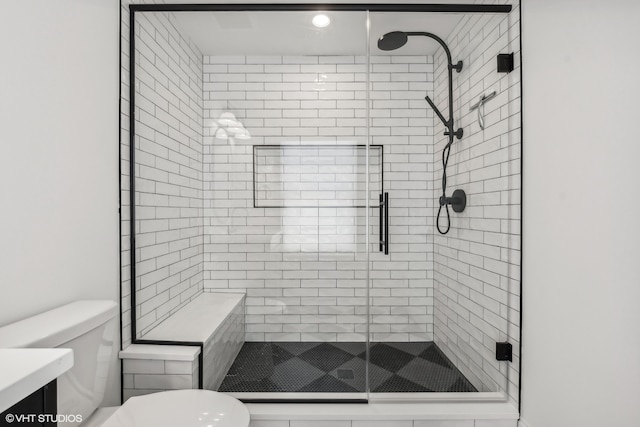 bathroom with a shower with shower door, vanity, and toilet