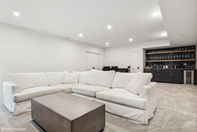 carpeted living room with beverage cooler and bar