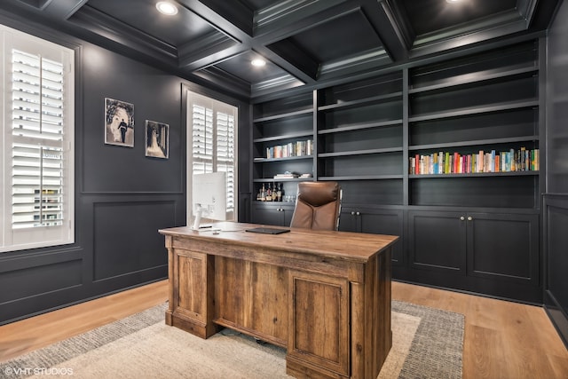 office featuring light hardwood / wood-style floors, crown molding, beamed ceiling, built in features, and coffered ceiling