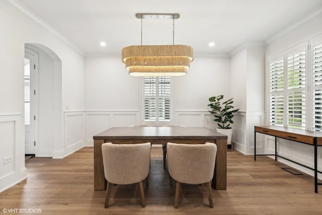 dining space with crown molding and wood-type flooring