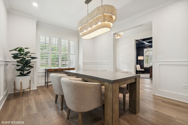 dining space with hardwood / wood-style flooring, ornamental molding, and plenty of natural light