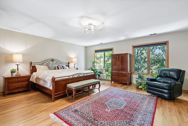 bedroom featuring light wood finished floors and visible vents