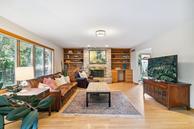 living room with light wood-type flooring and crown molding