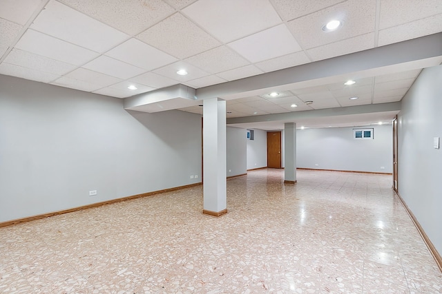 finished basement featuring a paneled ceiling, visible vents, baseboards, and recessed lighting