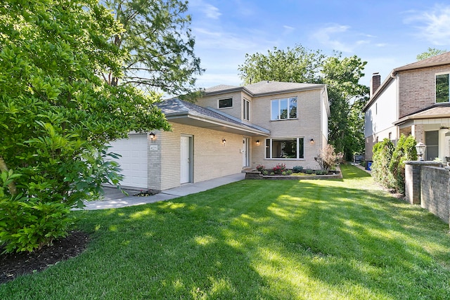 traditional-style house with brick siding, an attached garage, and a front yard