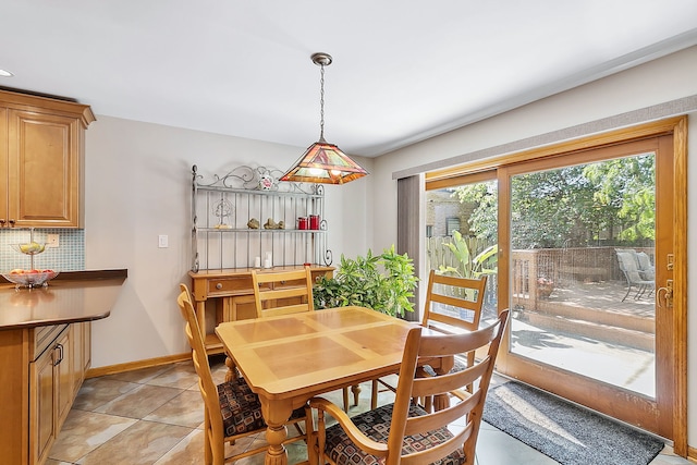 dining space featuring baseboards and light tile patterned flooring