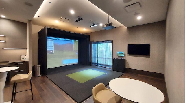 playroom with golf simulator and dark wood-type flooring