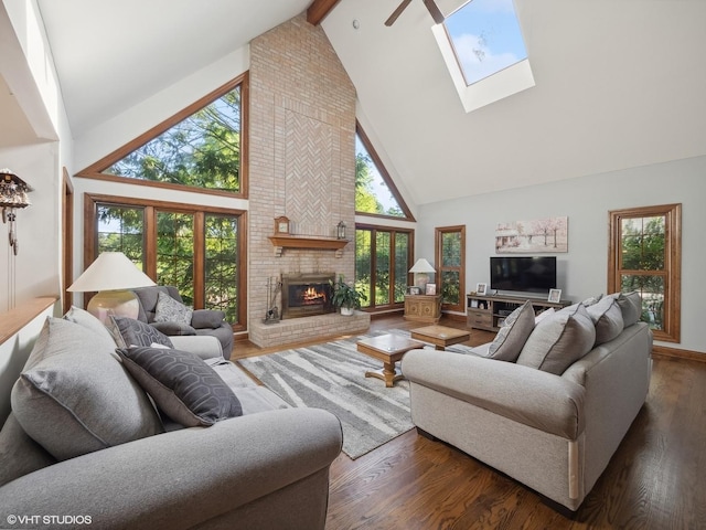 living room featuring beam ceiling, dark wood-type flooring, a fireplace, and a skylight