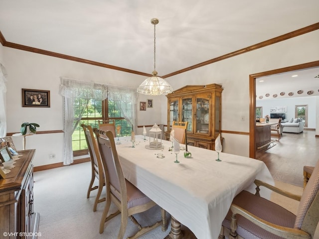 carpeted dining space with crown molding and a chandelier