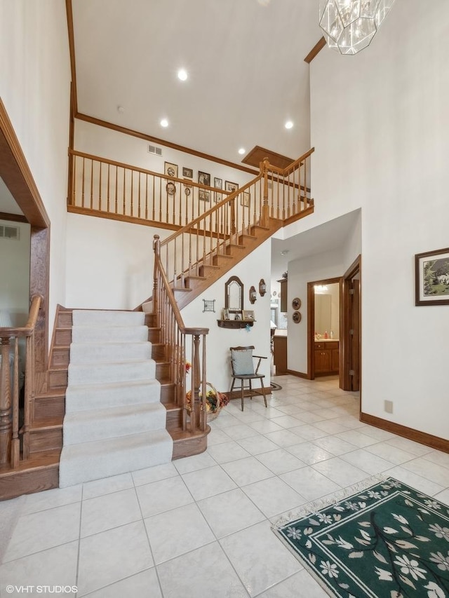 stairs featuring tile patterned flooring, a towering ceiling, and ornamental molding