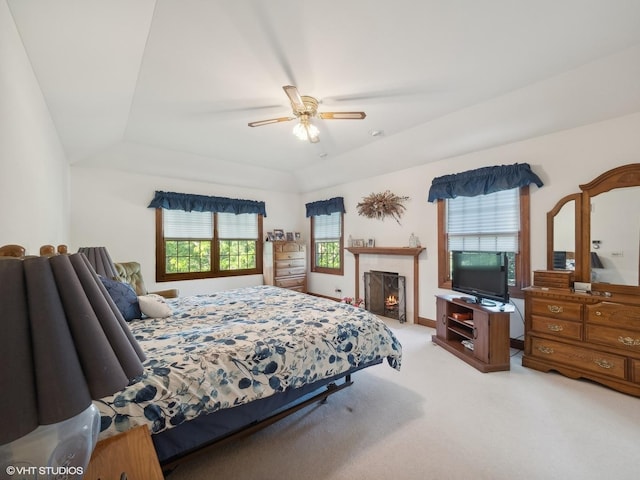 carpeted bedroom featuring ceiling fan and a tray ceiling