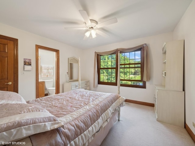 bedroom featuring ceiling fan, connected bathroom, and light carpet