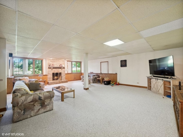 living room with a brick fireplace, a drop ceiling, and carpet