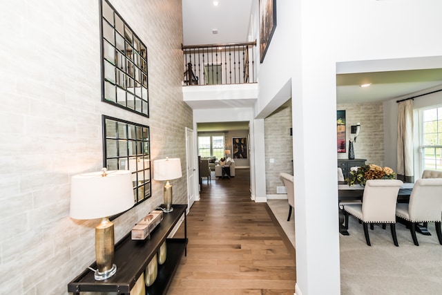 hallway featuring a towering ceiling and hardwood / wood-style flooring