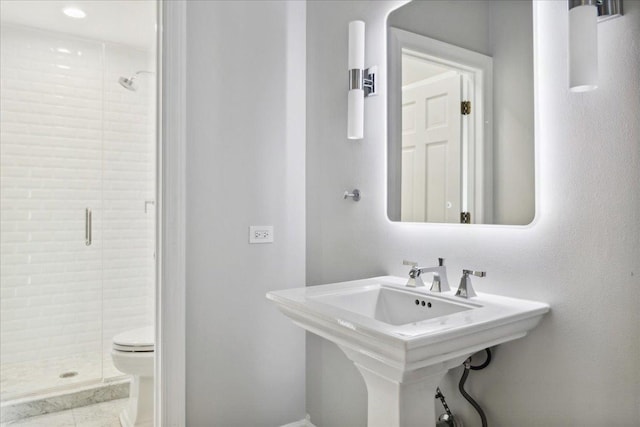 bathroom featuring walk in shower, sink, and toilet