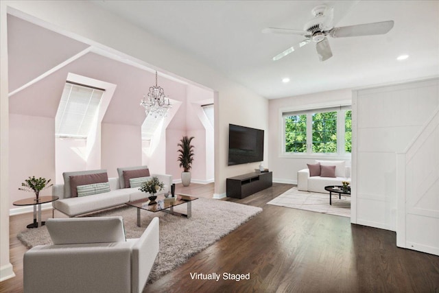 living room with dark hardwood / wood-style floors and ceiling fan with notable chandelier