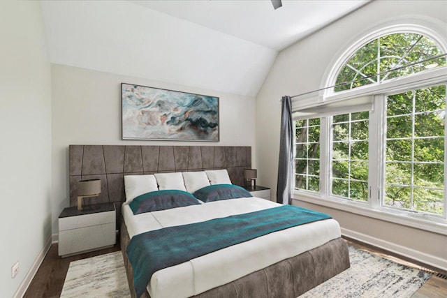 bedroom featuring hardwood / wood-style flooring, ceiling fan, lofted ceiling, and multiple windows