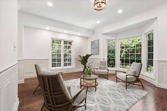 living area with dark wood-type flooring and ornamental molding