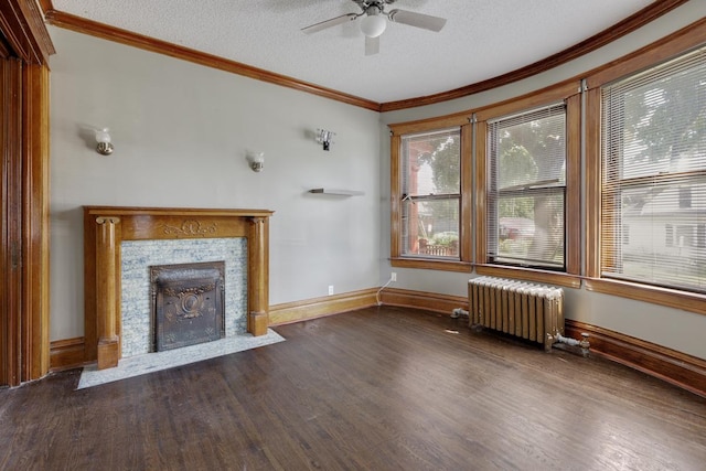 unfurnished living room with dark hardwood / wood-style floors, radiator heating unit, a tiled fireplace, ornamental molding, and a textured ceiling