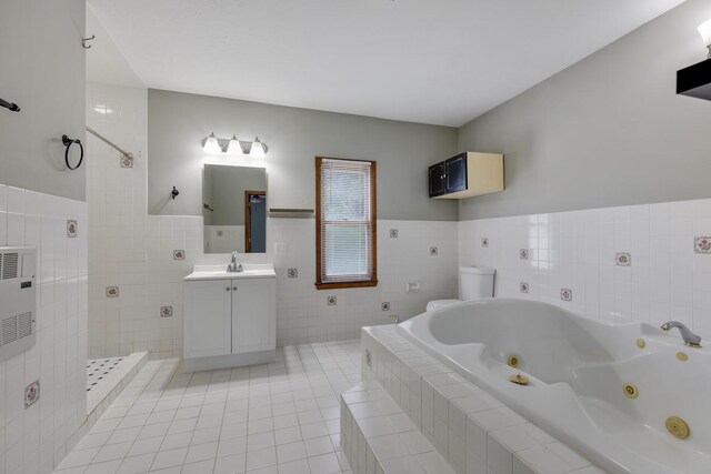 bathroom with toilet, vanity, tile patterned flooring, and tile walls