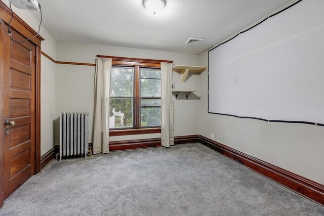 carpeted spare room featuring radiator heating unit