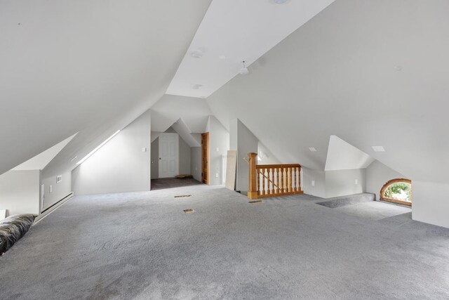 additional living space featuring carpet floors and vaulted ceiling