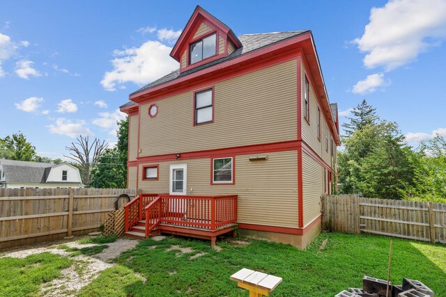 rear view of property featuring a yard and a deck