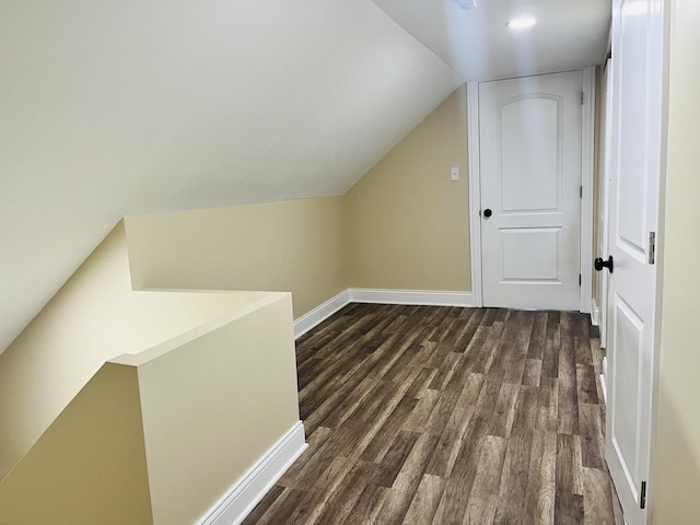 additional living space with dark hardwood / wood-style floors and vaulted ceiling