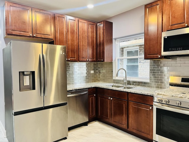 kitchen featuring decorative backsplash, sink, light stone countertops, and stainless steel appliances