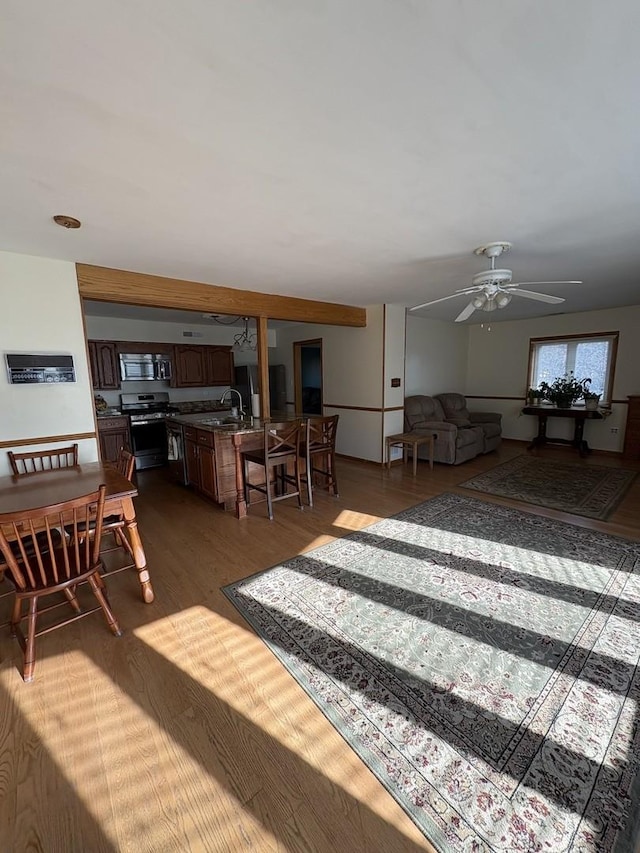 living room featuring sink, dark wood-type flooring, and ceiling fan