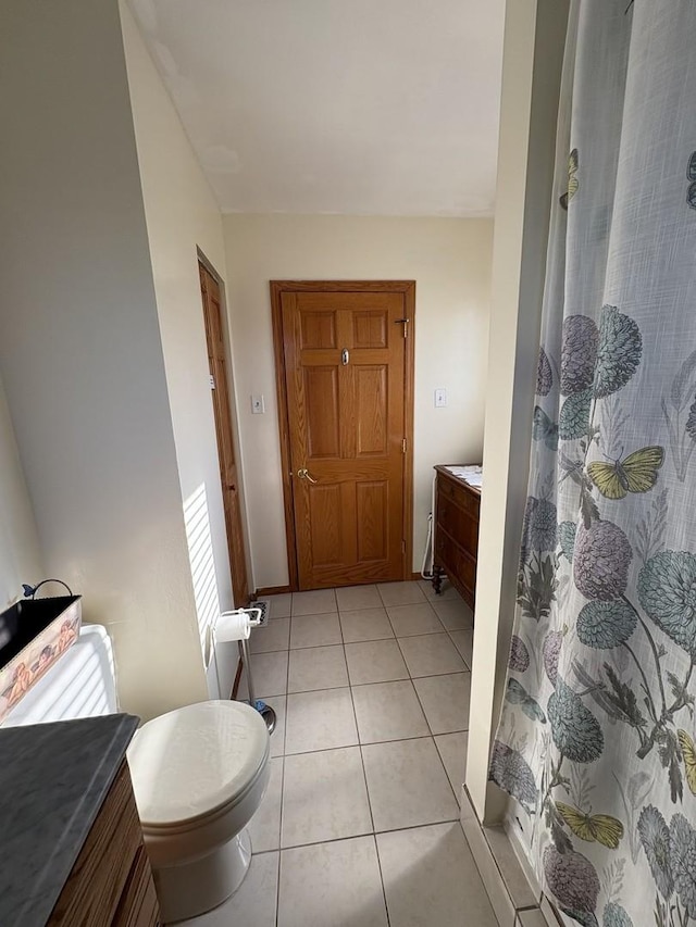 bathroom featuring tile patterned floors, a shower with curtain, and toilet