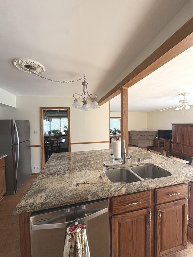 kitchen featuring sink, stainless steel appliances, and light stone counters