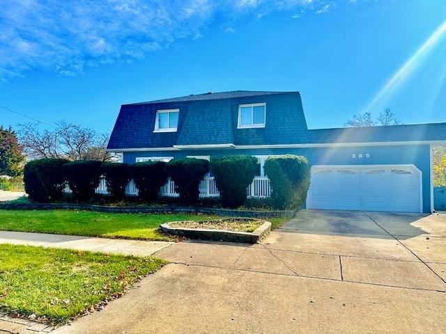 front of property featuring a front lawn and a garage