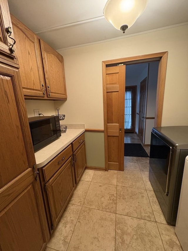 kitchen featuring light tile patterned floors, washer / clothes dryer, and ornamental molding