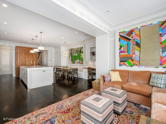 living room featuring a chandelier, sink, dark hardwood / wood-style floors, and ornamental molding