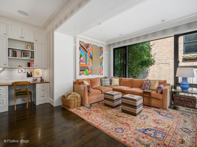 living room with built in desk, dark hardwood / wood-style flooring, and ornamental molding