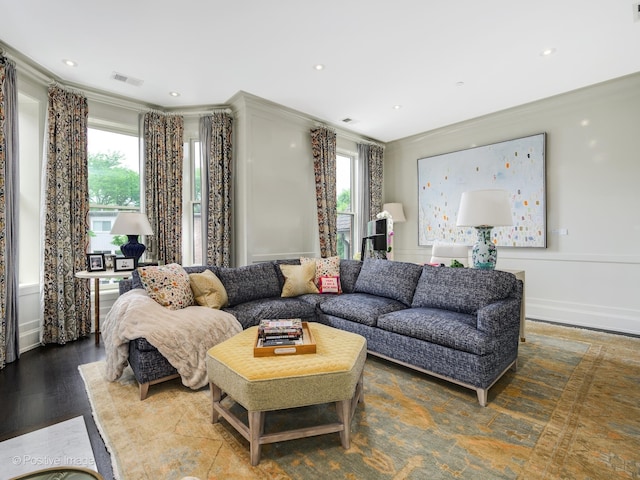 living room with a wealth of natural light, crown molding, and hardwood / wood-style flooring